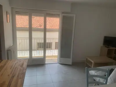 a living room with sliding glass doors and a table at studio 30m2 in Nice