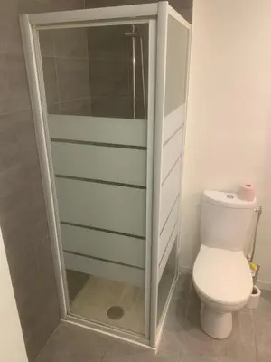 a bathroom with a toilet and a glass shower door at studio 30m2 in Nice