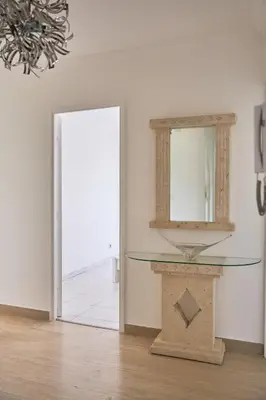 a mirror on top of a table in front of a door at Appartement Moderne 4 pièces Nice-Ouest in Nice