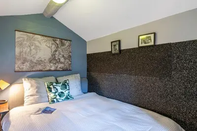 a bedroom with a bed with a black accent wall at Cute duplex studio in Nice