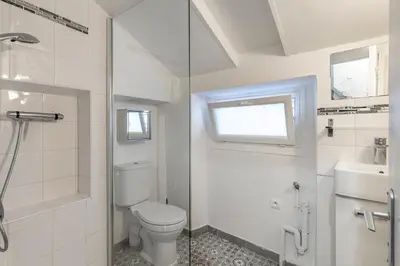 a white bathroom with a toilet and a sink at Cute duplex studio in Nice
