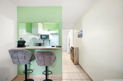 a kitchen with two bar stools and a counter at Studio Nice , proche mer et aéroport in Nice