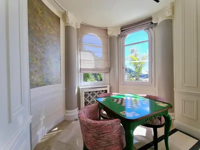 a dining room with a green table and two chairs at Villa Soleil Riviera in Villefranche-sur-Mer
