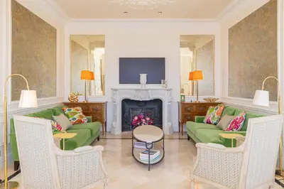 a living room with green couches and a fireplace at Villa Soleil Riviera in Villefranche-sur-Mer
