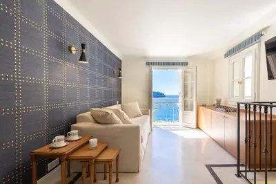 a living room with a couch and a table at Villa Soleil Riviera in Villefranche-sur-Mer