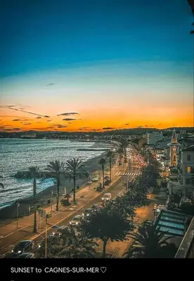 a sunset over a beach with a city and the ocean at Appartement-Centre ville -Climatisé-Terrasse-Parking in Cagnes-sur-Mer