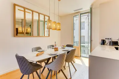 a kitchen and dining room with a table and chairs at 33 MARINONI AP4438 by Riviera Holiday Homes in Beaulieu-sur-Mer