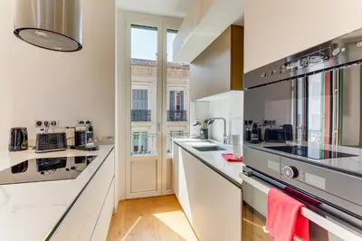 a large kitchen with white counter tops and appliances at 33 MARINONI AP4438 by Riviera Holiday Homes in Beaulieu-sur-Mer