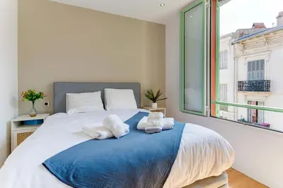 a bedroom with a large bed with towels on it at 33 MARINONI AP4438 by Riviera Holiday Homes in Beaulieu-sur-Mer