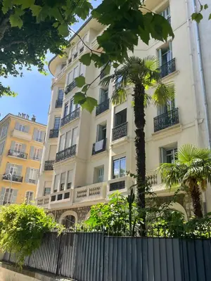 a tall white building with a palm tree in front of it at Studio Carabacel in Nice