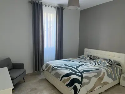 a bedroom with a bed and a chair and a window at Katy in Nice