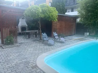 a swimming pool with chairs and a table and a tree at Katy in Nice