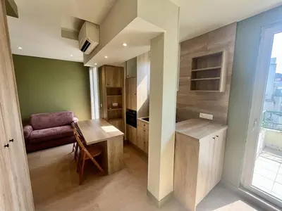 a kitchen with a table and a couch in a room at Nice Signature Halevy Terrasse in Nice