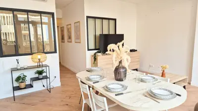 a dining room with a white table and chairs at Superbe appartement 3P neuf - terrasse - barbecue in Nice
