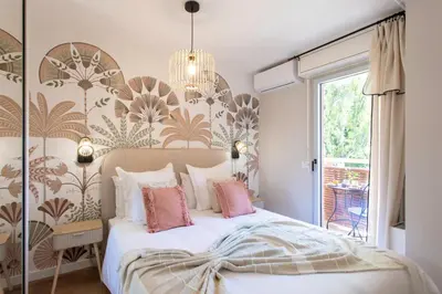 a bedroom with a large bed with pink pillows at Appartement cosy lumineux avec balcon in Nice