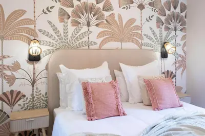 a bedroom with a bed with pink and white pillows at Appartement cosy lumineux avec balcon in Nice