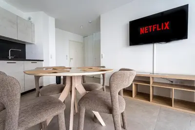 a kitchen with a table with chairs and a tv at Le Bô Mont in Nice