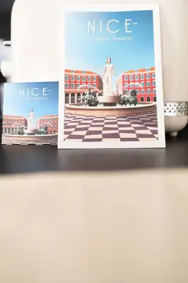 two pamphlets sitting on a shelf with a picture of a statue at Le Bô Mont in Nice