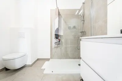 a white bathroom with a shower and a toilet at Le Bô Mont in Nice