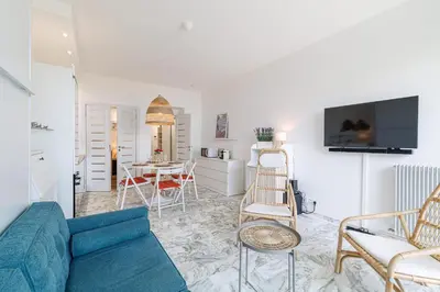 a living room with a blue couch and a table at Sea View & Terrace Promenade des Anglais in Nice