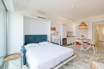 a bedroom with a large bed and a table and chairs at Sea View & Terrace Promenade des Anglais in Nice