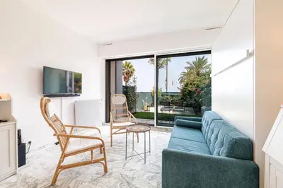 a living room with a blue couch and chairs at Sea View & Terrace Promenade des Anglais in Nice