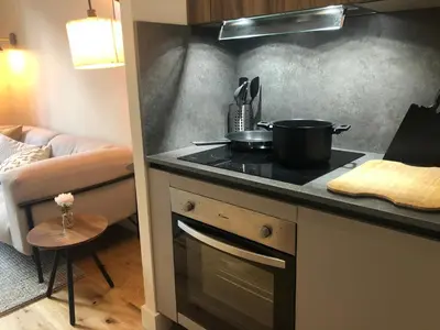 a kitchen with a stove top oven next to a couch at MAYERBEER - Apartment 2 bedrooms with balcony in Nice