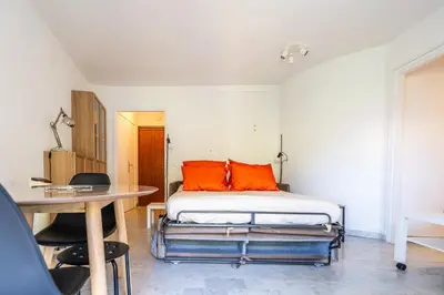 a bedroom with a bed with orange pillows and a table at L'Échappée Belle in Nice