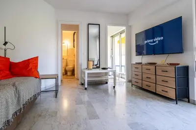 a bedroom with a bed and a large screen television at L'Échappée Belle in Nice