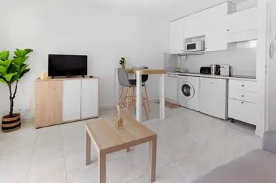 a kitchen with white cabinets and a table in a room at Le Seaside - Beach - Tram - Airport - AC in Nice
