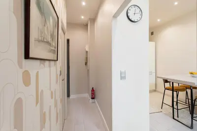a hallway with a clock on the wall and a table at #3 Mascoinat 1BDR Old Town, near beach Fan & WIFI in Nice