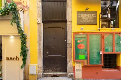 a yellow building with a black door and a window at #3 Mascoinat 1BDR Old Town, near beach Fan & WIFI in Nice