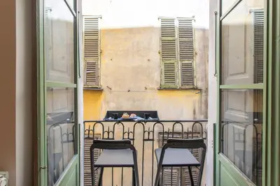a balcony with three chairs and a table with a laptop at #3 Mascoinat 1BDR Old Town, near beach Fan & WIFI in Nice