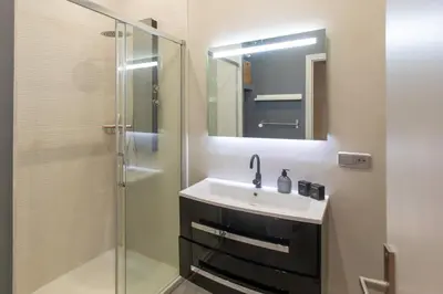 a bathroom with a sink and a glass shower at #3 Mascoinat 1BDR Old Town, near beach Fan & WIFI in Nice