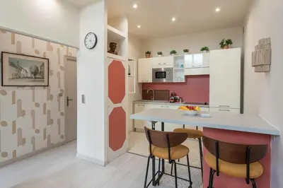 a kitchen with a table and two chairs and a clock at #3 Mascoinat 1BDR Old Town, near beach Fan & WIFI in Nice
