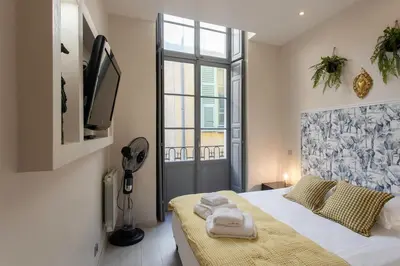a bedroom with a bed and a tv and a window at #3 Mascoinat 1BDR Old Town, near beach Fan & WIFI in Nice