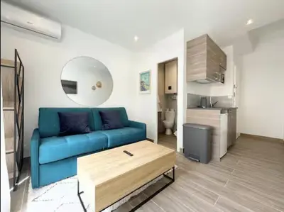 a living room with a blue couch and a table at Studio en plein centre de Nice, proche Tramway in Nice