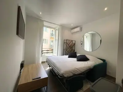 a small bedroom with a bed and a mirror at Studio en plein centre de Nice, proche Tramway in Nice