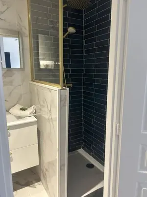 a bathroom with a shower with a blue tile wall at MOON - 31 in Nice