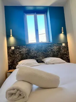a bedroom with a bed with a blue wall and a window at MOON - 37 in Nice