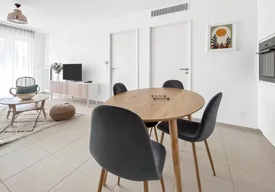 a dining room with a wooden table and chairs at Spacieux T2 à 150m Des Plages in Cagnes-sur-Mer