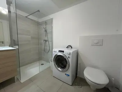 a bathroom with a washing machine and a toilet at Spacieux T2 à 150m Des Plages in Cagnes-sur-Mer