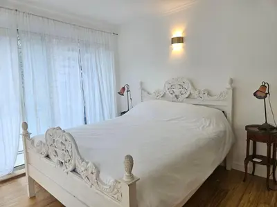 a white bed in a white bedroom with windows at Villa Ninette avec rooftop in Villefranche-sur-Mer