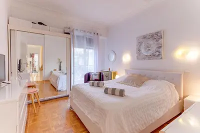 a bedroom with a large white bed and a desk at LE LAFAYETTE 2 AP4474 by Riviera Holiday Homes in Nice