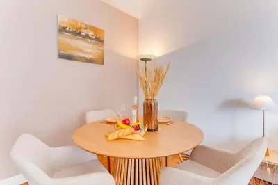 a dining room with a wooden table and white chairs at LE LAFAYETTE 2 AP4474 by Riviera Holiday Homes in Nice