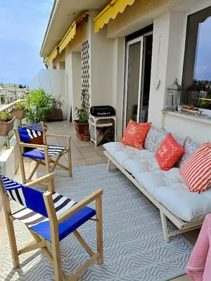 a couch on a patio with two chairs and a grill at Stunning 2 bedroom apartment with Terrace and Sea view, Nice Cimiez Liberation in Nice