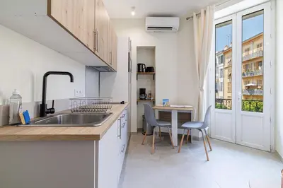 a kitchen with a sink and a table with chairs at T2 situé au centre-ville de Nice in Nice