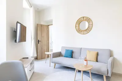 a living room with a blue couch and a mirror at T2 situé au centre-ville de Nice in Nice