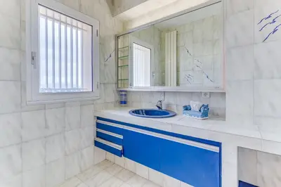 a bathroom with a blue sink and a mirror at VILLA DYONIS VI4439 by Riviera Holiday Homes in Nice