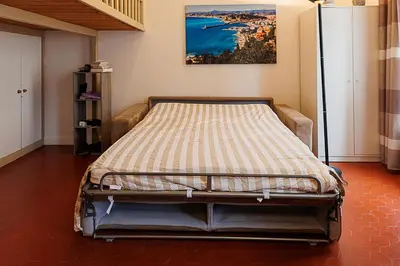 a living room with a couch and a table at charmant studio sur le port de Nice in Nice